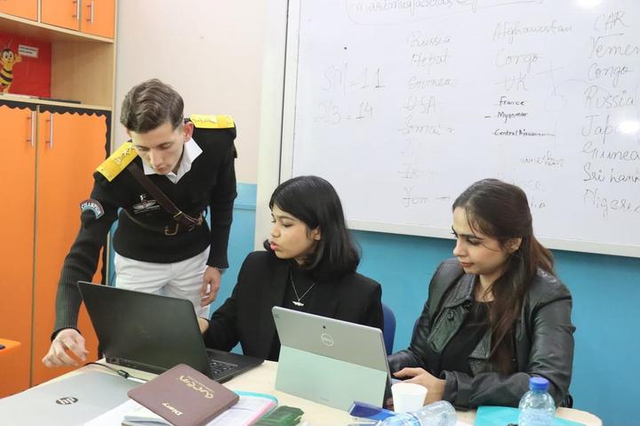 Delegates working together on laptops in committee